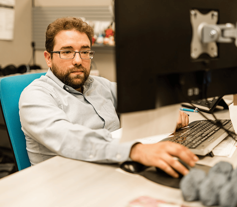 a man sitting at a table using a laptop computer