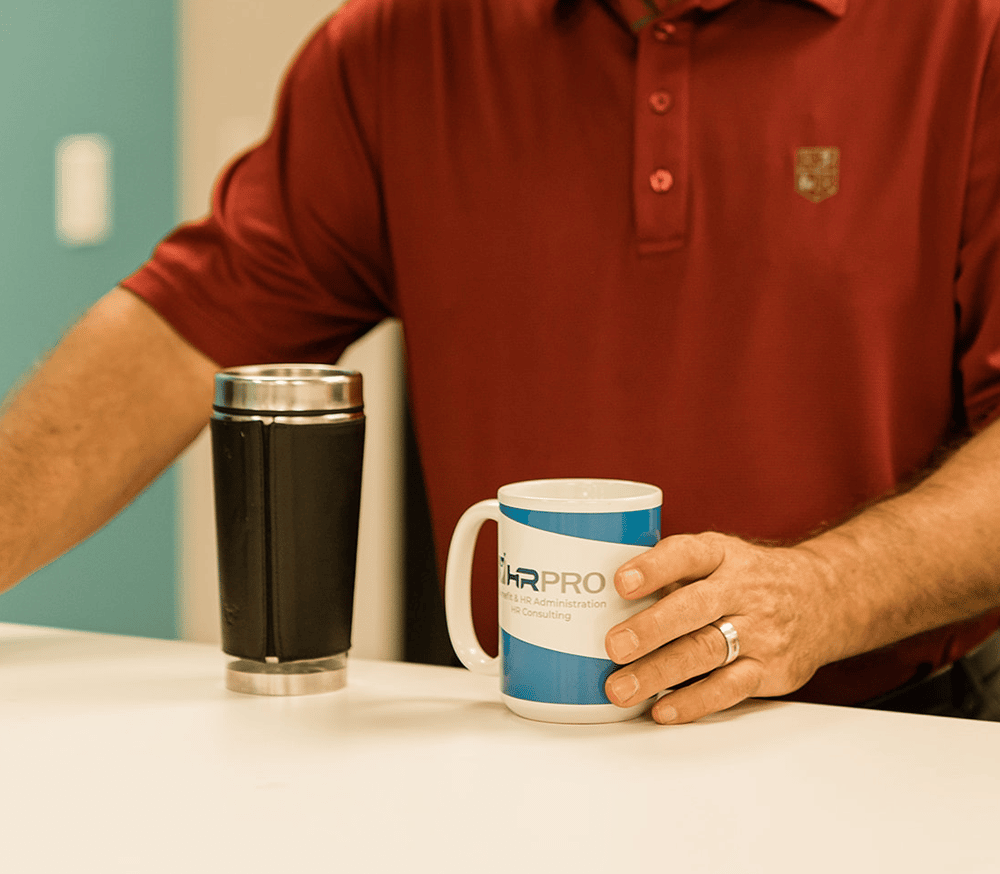 a man sitting at a table with a cup of coffee