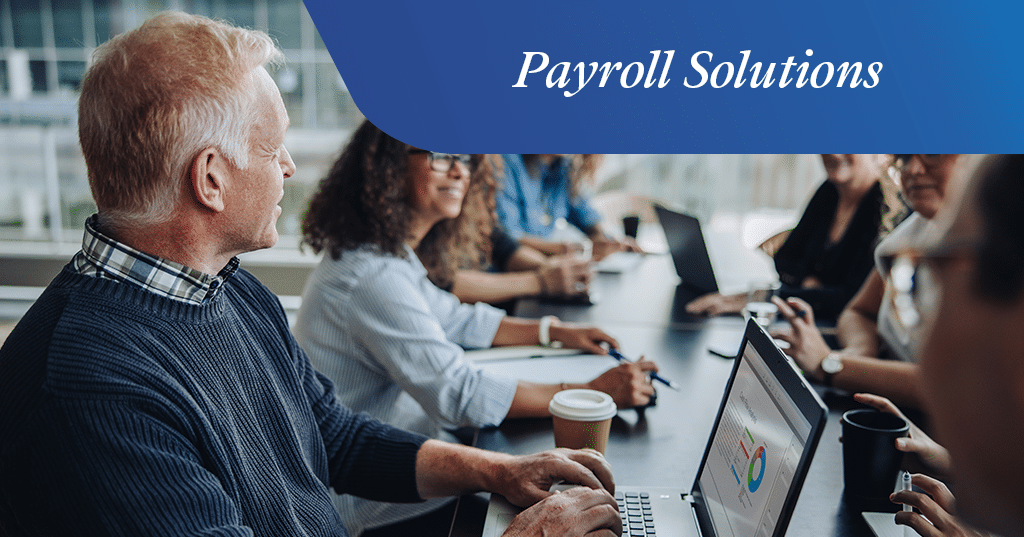 a group of people looking at a laptop