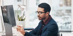 a man standing in front of a laptop